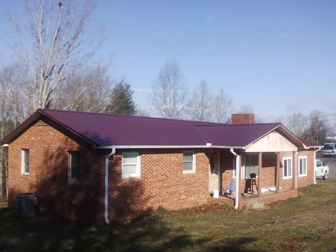 Burgundy metal roof on a brick ranch home with a new addition in Mead