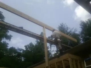 Carpenter setting a ridge beam over a new addition frame — Ice Dam Removal by Roofing Brothers in Mead