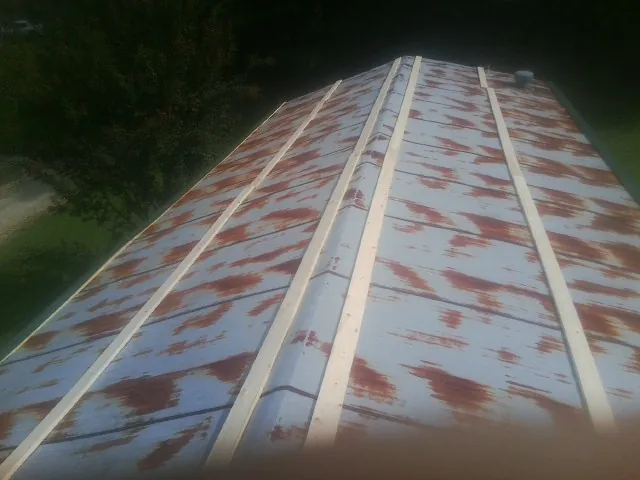 Rusted metal roof panels with new wood purlins before replacement — Storm Damage Roof Repair in Mead by Roofing Brothers